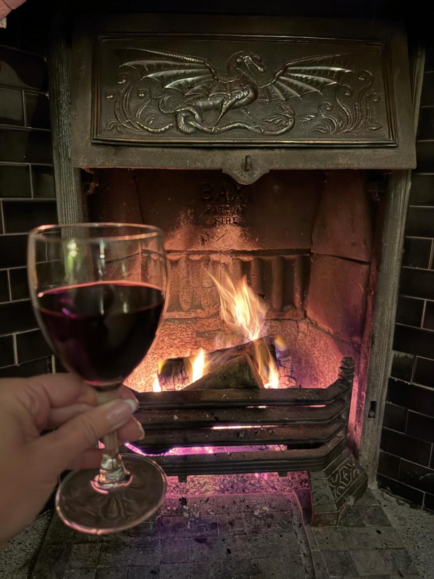 Clone Country House Aughrim Exterior foto A glass of red wine in front of a fireplace